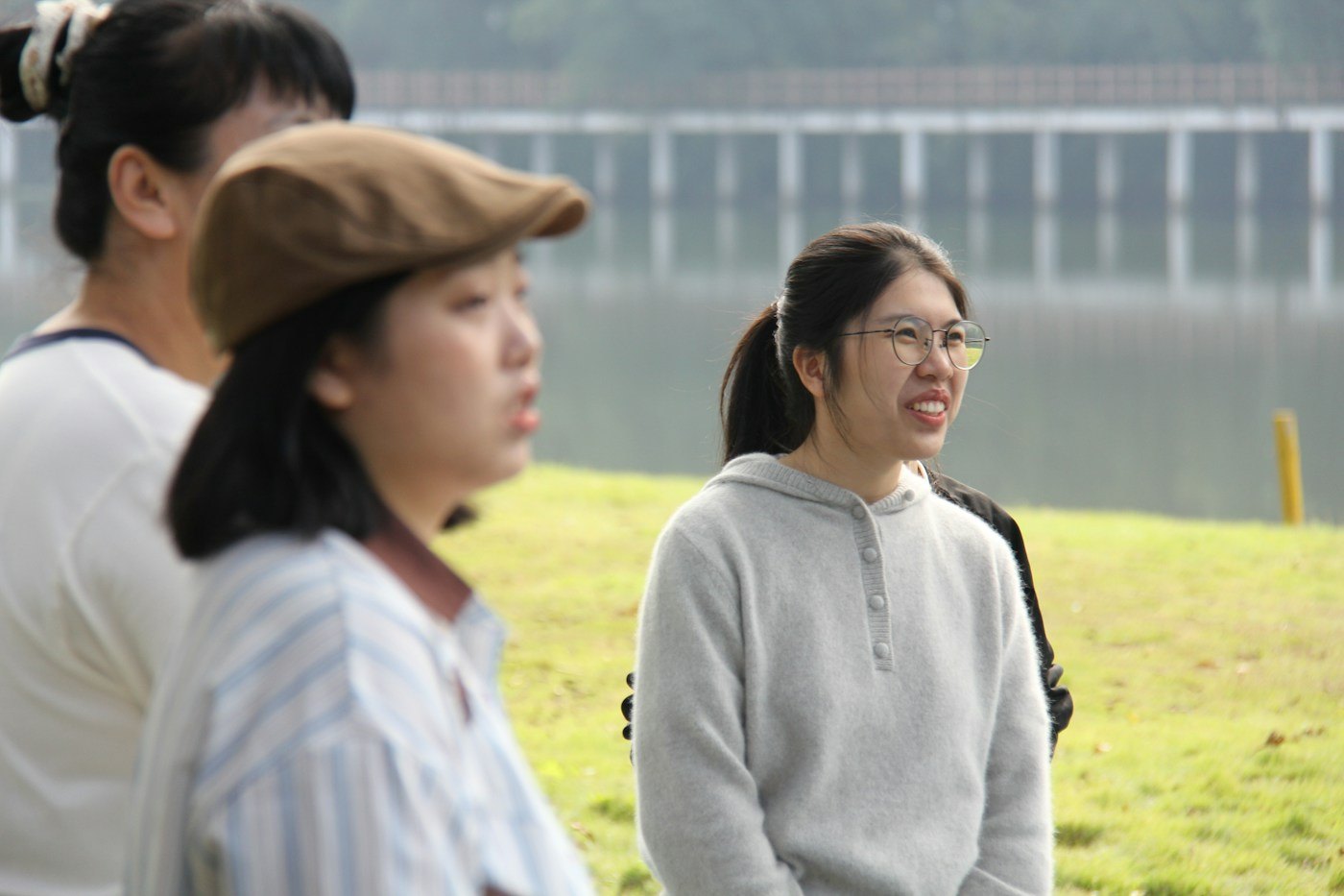 Three women spending time together beside a lake