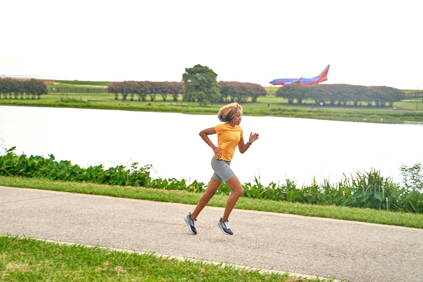 Woman running along a path beside a lake